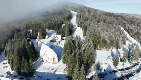 Aerial-view-of-ski-slopes,-Trije-kralji-winter-resort-on-Pohorje,-Slovenia,-few-people-due-covid-restrictions-are-able-to-enjoy-outdoor-activities