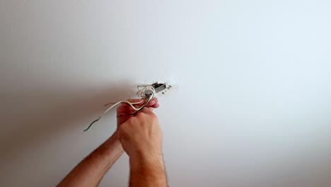 Fasten-a-screw-to-a-ceiling-light-mount