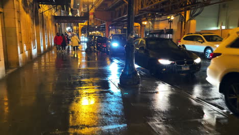First-person-walking-view-of-a-busy-street-in-Chicago-at-night-in-the-rain