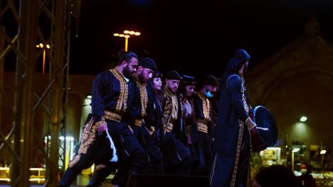 A-group-of-guys-dancing-Palestinian-dabka-on-stage-with-a-lead-dancer-to-guide-them