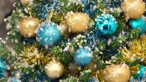 Christmas-tree-snow-falling-on-golden-and-blue-ball-at-winter-night