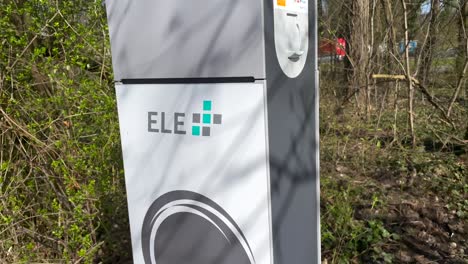 Trucking-down-shot-of-Electro-Charging-Station-ELE-for-Plug-in-Hybrid-or-electric-Cars-in-nature