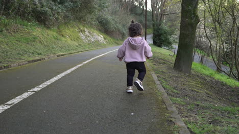 Back-view-of-toddler-running,-then-laughing-looking-at-camera