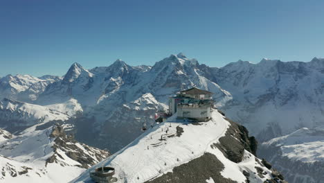 Drohne-Umkreist-Skiliftgebäude-Mit-Terrasse-Auf-Dem-Schneebedeckten-Berg
