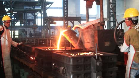 Foundry-worker-pouring-hot-metal-into-cast