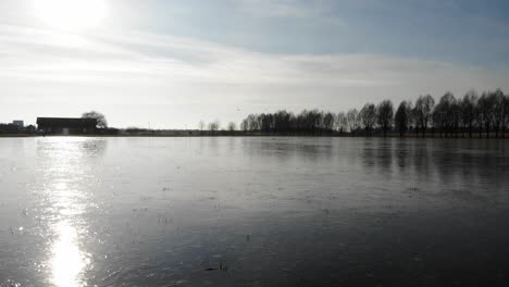 Sunlight-Reflection-Through-Frozen-River-From-Hendrik-Ido-Ambacht-Near-Sandelingen-Park-In-South-Holland,-Netherlands