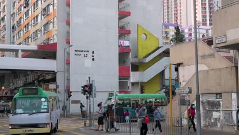 Se-Ve-A-Los-Peatones-Caminando-Por-Un-Paso-De-Cebra-Cerca-De-Un-Complejo-De-Viviendas-Públicas-En-Hong-Kong.