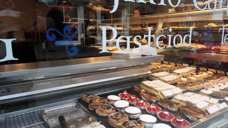 Mirando-La-Exhibición-De-Deliciosos-Pasteles-En-La-Ventana-De-La-Tienda-De-Pasteles-De-La-Panadería-Conwy