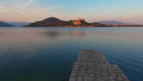 Friedliche-Szene-Der-Betonmole-Am-Lago-Maggiore-Ruhiges-Wasser-In-Italien,-Schloss-Angera-Im-Hintergrund