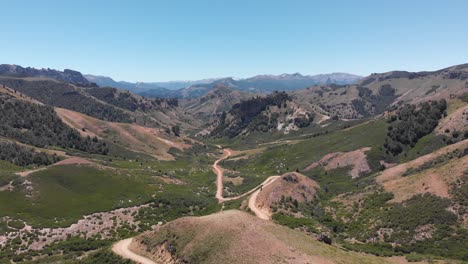 Aerial-view-of-a-winding-dirt-road-through-the-mountains