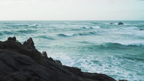 Blue-ocean-waves-crushing-into-a-a-rocky-beach