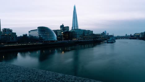 Time-lapse-of-City-Hall,-London-UK,-as-night-settles-in-and-boats-sail-on-the-river-Thames
