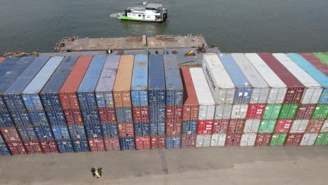 Boot-Segelt-Auf-See-In-Der-Nähe-Eines-Stapels-Von-Frachtcontainern-Im-Containerhafenlager-In-Dordrecht,-Niederlande