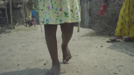 Young-Indian-poor-orphan-girl,-walking-on-road-with-naked-dirty-feet