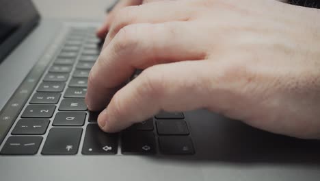Male-hands-type-on-a-notebook-keyboard