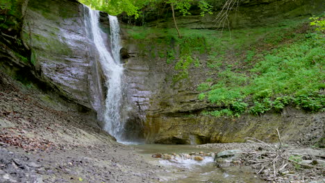 Zeitlupenvergrößerung-Des-Schwebenden-Wasserfalls-An-Der-Moosigen-Felswand,-Umgeben-Von-Grüner,-Idyllischer-Natur