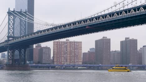 Yellow-Water-Taxi-Passagierfähre-Auf-Dem-Hudson-River-Mit-Stadtbild,-Verkehr-Im-Hintergrund-Und-Einer-Brücke-Darüber-In-New-York,-New-York-City