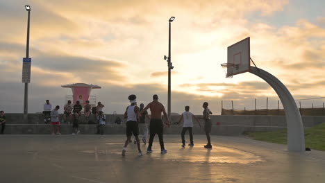 Männer-Spielen-In-Der-Abenddämmerung-Basketball-Auf-Einem-Basketballplatz-Im-Freien-In-Imperial-Beach,-Kalifornien