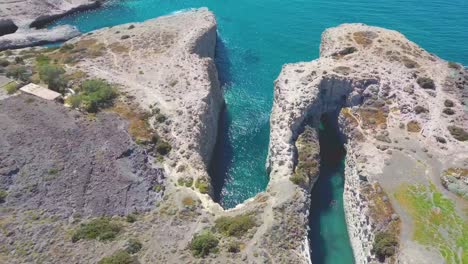 Aerial-view-to-the-popular-Papafragas-cave-beach-situated-in-volcaninc-landscape-with-turquoise-waters,-Milos-island,-Greece