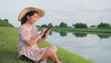 Adult-woman-sitting-on-the-lawn-using-portable-technology