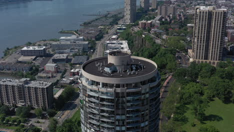 A-drone-view-of-a-tall-cylindrical-building-on-the-New-Jersey-side-of-the-Hudson-River-on-a-sunny-day