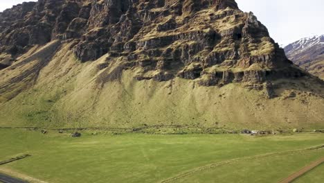 Iceland-Farm-Fields-with-jagged-Rocky-Mountain-off-of-ring-road