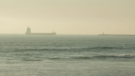 Freight-Barge-Sailing-Across-The-Sea-Obscure-By-Morning-Fog-In-Figueira-da-Foz,-Portugal