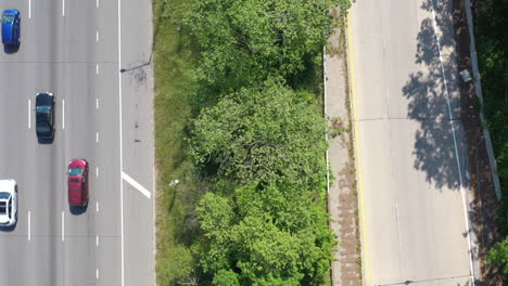 A-top-down-view-directly-over-a-parkway-median-with-green-trees-and-grass