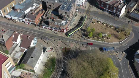 Drone-shot-over-Croydon-old-town-following-a-modern-green-tram
