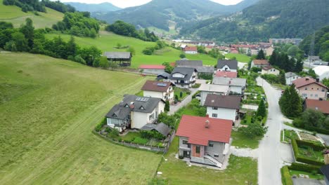 Flying-in-front-of-small-settlement-of-family-houses-between-beautiful-green-nature