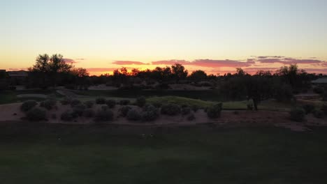 Silhouette-Parallaxenansicht-Eines-Sonnenuntergangs-Auf-Einem-Luxus-Golfplatz