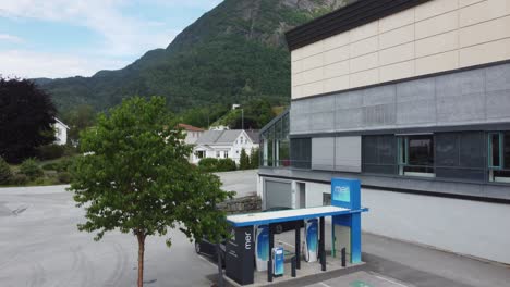Charging-station-for-electric-cars---mer-station-from-Statnett-in-Leikanger-Norway---Descending-aerial-revealing-charging-station-with-customers