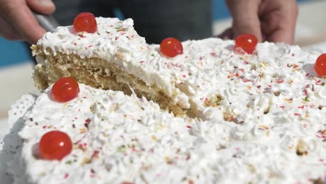 Serving-homemade-white-cream-cake-in-a-sunny-day-outside-near-the-swimming-pool-at-a-celebration-party