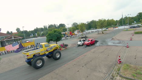 Monstertruck-Mit-Amerikanischen-Und-Europäischen-Flaggen-Fährt-Während-Der-Team-Lagrin-Stuntshow-In-Deutschland-über-Zwei-Autos