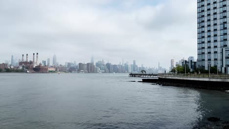 North-Williamsburg-Pier-on-a-gloomy-morning-looking-across-the-East-River-to-Manhattan-skyline-with-the-Empire-State-Building-in-clouds