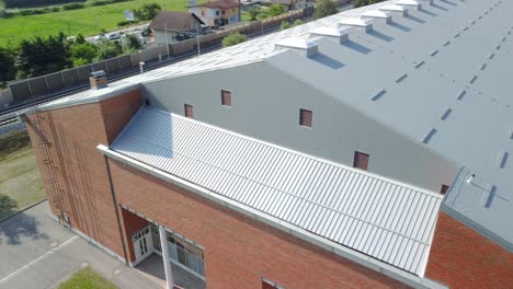 Fliegend-Neben-Roten-Lehmziegeln-Wird-Eine-Sporthalle-Mit-Grauen-Dämmplatten-Gebaut,-Die-Als-Dach-Verwendet-Werden