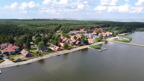 Fly-towards-resort-town-of-Pervalka-on-sunny-day-in-Lithuania,-Neringa-region