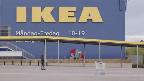 Ein-Junger-Mann-Geht-Durch-Einen-Verlassenen-IKEA-Parkplatz-In-Schweden