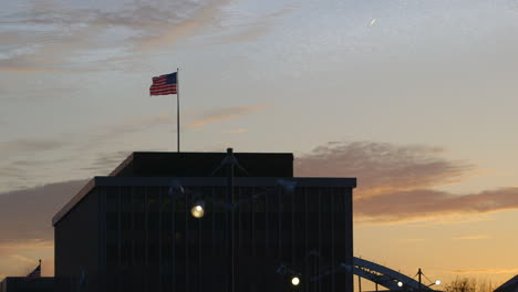 Bandera-Estadounidense-En-La-Azotea-Del-Edificio-De-La-Sede-De-Los-Leñadores-Modernos-De-América-En-Rock-Island,-Illinois-Al-Amanecer