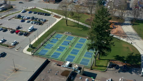Tennisspieler-In-Einem-Stadtpark,-Drohnen-Dolly-über-Den-Sportplätzen