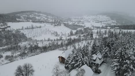 Verschneite-Bergpanoramaaufnahme-Mit-Holzhütte-Und-Schneebedecktem-Wald