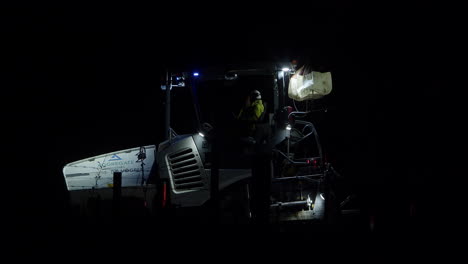 Men-In-Reflectorized-Uniform-Talking-While-Sitting-In-A-Road-Paver-Machine-At-Night