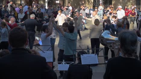 Menschen-Tanzen-Sardana-Auf-Der-Straße,-Während-Musiker-In-Barcelona-Musik-Spielen