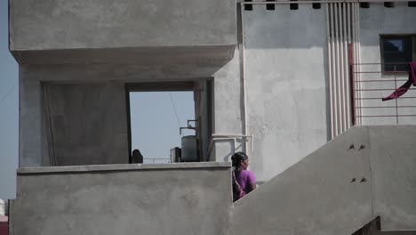Indisches-Dienstmädchen,-Das-Die-Blicke-Eines-Halbfertigen-Hauses-In-Indien-Hinuntergeht