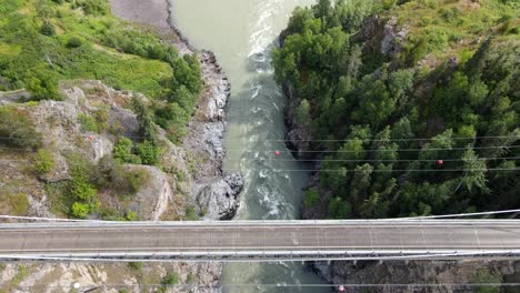 4k-vertical-top-down-view-of-cars-driving-across-Hagwilget-canyon-bridge-in-northern-British-Columbia
