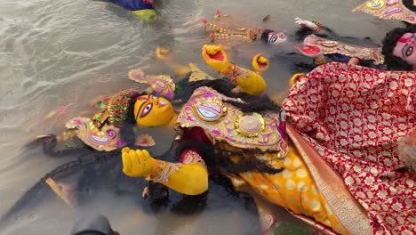 An-unidentified-youth-submerging-a-big-statue-of-Hindu-goddess-Durga-on-the-occasion-of-Durga-Visarjan-on-Vijaya-Dashami-in-Kolkata,-West-Bengal,-India