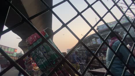 View-through-the-guard-railings-from-inside-an-auto-rickshaw-the-traffic-congestion-in-the-streets-of-Dhaka,-Bangladesh
