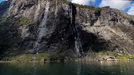 Towering-rock-walls-of-the-Geiranger-Fjord-seven-sisters-Waterfall-of-Norway