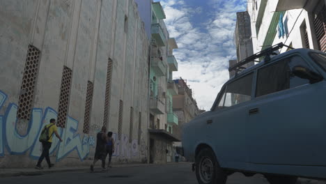 Calle-Havana-Con-Autos-Antiguos,-Peatones-Y-Graffiti