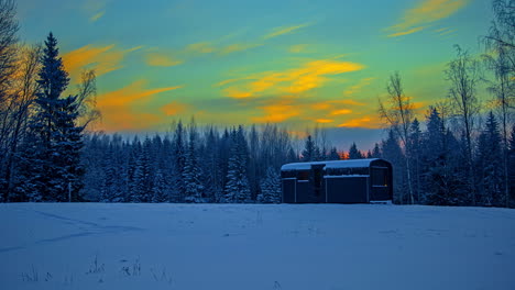 Beautiful-Sunrise-Over-Cabin-House-On-Snowy-Landscape-At-The-Countryside